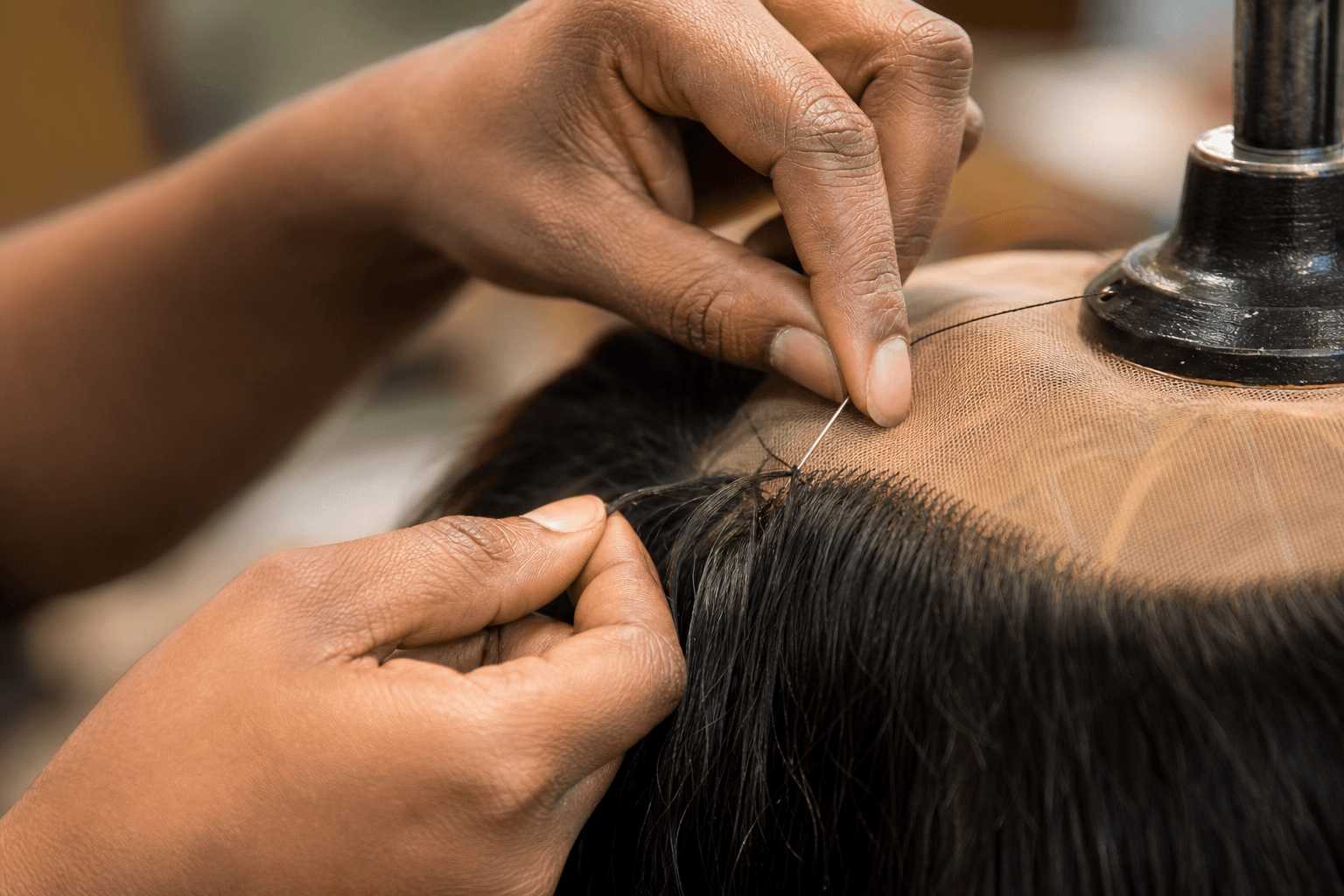 Artisan carefully inspecting a handcrafted lace wig cap